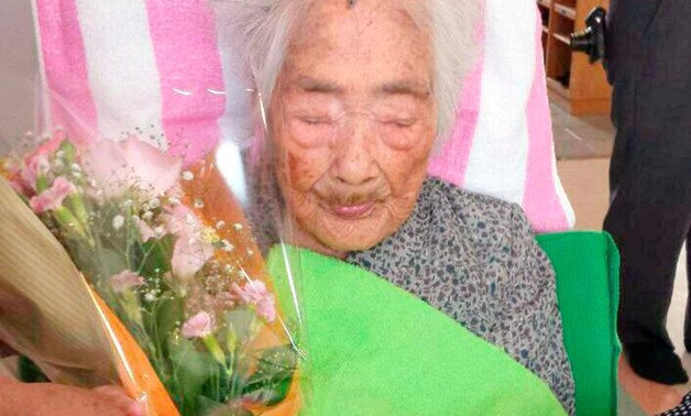 Nabi Tajima, born in 1900, holds a bouquet in Japanese southwestern island of Kikaijima, Kagoshima Prefecture, Japan, in this photo taken in 2015 - Reuters
