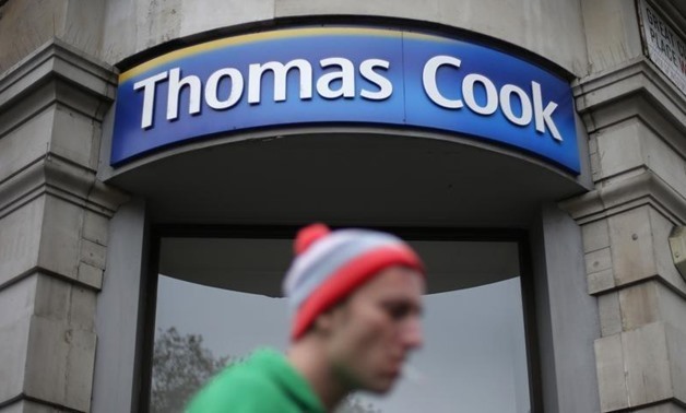 A pedestrian walks past a Thomas Cook shop in central London, November 26, 2014. REUTERS/Suzanne Plunkett