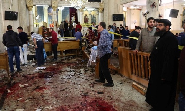 A general view shows people looking at the aftermath following a bomb blast which struck worshippers gathering to celebrate Palm Sunday at the Mar Girgis Coptic Church in the Nile Delta City of Tanta, north of Cairo, on April 9, 2017. (AFP Photo/Stringer)