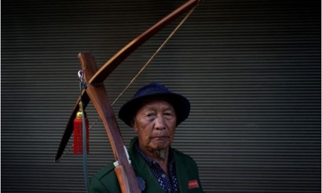 An ethnic Lisu man carries his crossbow as he poses for a photograph during a crossbow shooting competition in Luzhang township of Nujiang Lisu Autonomous Prefecture in Yunnan province, China, March 29, 2018. REUTERS/Aly Song