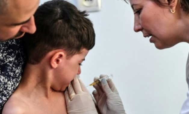 AFP/File | A child receives a vaccination against measles by a family physician on April 16, 2018 in the Romanian capital, Bucharest
