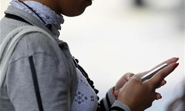 A woman uses her mobile phone in Caracas, March 29, 2010. REUTERS/Jorge Silva