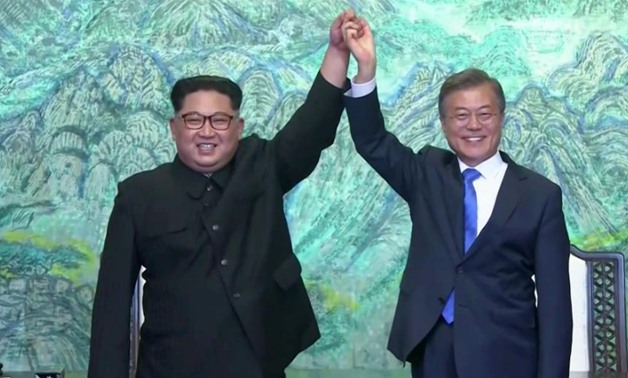 South Korean President Moon Jae-in and North Korean leader Kim Jong Un gesture after signing agreements during the inter-Korean summit at the truce village of Panmunjom, in this still frame taken from video, South Korea April 27, 2018. Host Broadcaster vi