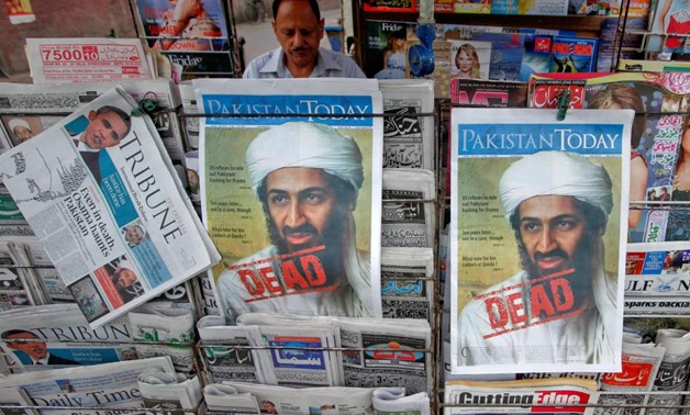 A roadside vendor sells newspapers with headlines about the death of al Qaeda leader Osama bin Laden, in Lahore May 3, 2011. REUTERS/Mohsin Raza/File Photo