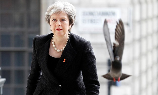 FILE PHOTO: A pigeon flies ahead of British Prime Minister Theresa May as she arrives for an event in London, April 23, 2018. REUTERS/Peter Nicholls/File Photo