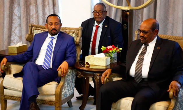 Ethiopian Prime Minister Abiy Ahmed (L) meets with Sudanese President Omar al-Bashir (R) following his arrival in Khartoum for an official visit to Sudan on May 2, 2018. / AFP / ASHRAF SHAZLY