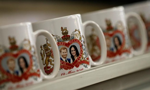 Mugs commemorating the wedding of Britain's Prince Harry and Meghan Markle move along a conveyor belt at the Prince William Pottery Company in Liverpool - REUTERS