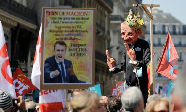 A protester holds a figure mocking Emmanuel Macron at the "The party for Macron" rally to protest the policies of the French president on the first anniversary of his election
