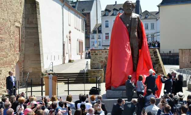 Visitors look on as a statue of German revolutionary thinker Karl Marx is unveiled in his native city © dpa/AFP / Harald Tittel
