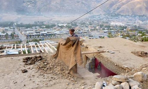 A man clears rubble from the roof of his house after an earthquake in Fayzabad, capital of Badakhshan province, Afghanistan October 26, 2015. REUTERS/Stringer

