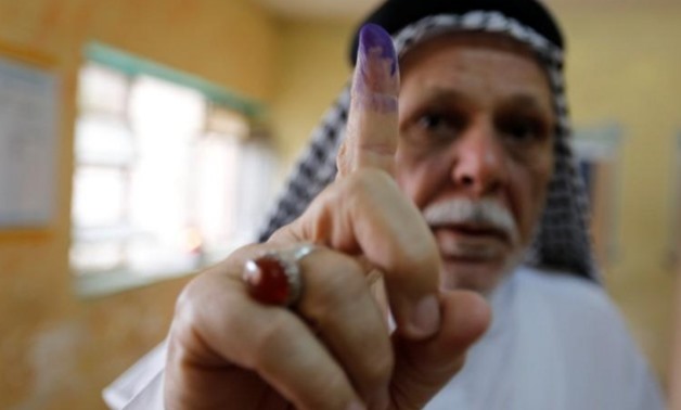 An Iraqi man shows his ink-stained finger after casting his vote at a polling station during the parliamentary election in the Sadr city district of Baghdad, Iraq May 12, 2018. REUTERS/Wissm al-Okili