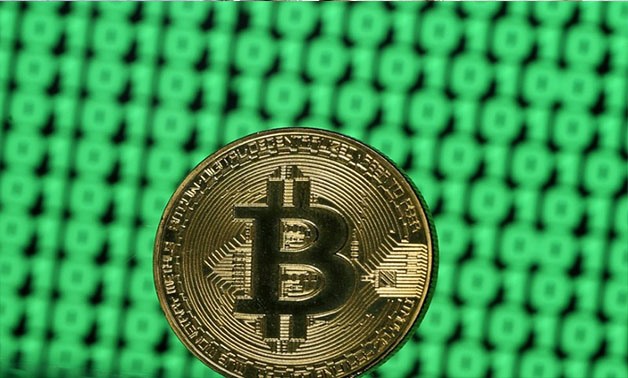 A token of the virtual currency Bitcoin is seen placed on a monitor that displays binary digits in this illustration picture, December 8, 2017. REUTERS/Dado Ruvic//File Photo