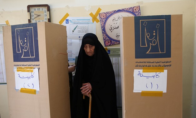 An Iraqi woman prepares herself to cast her vote at a polling station during the parliamentary election in Baghdad, Iraq May 12, 2018. (Reuters)