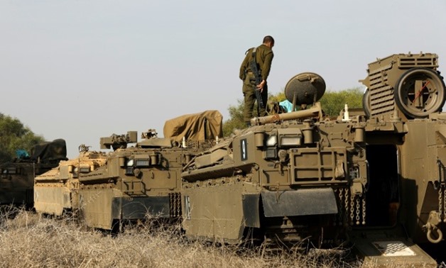 An Israeli soldier stands on an armoured personnel carrier (APC) as troops are on alert along the border with the Gaza Strip on November 13, 2017
