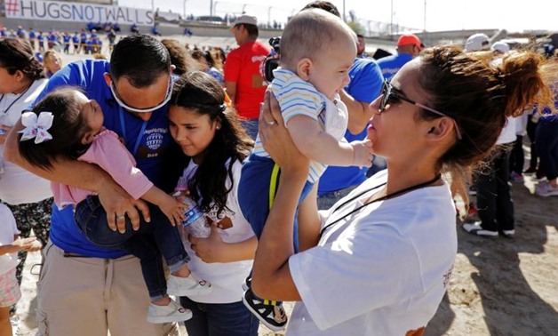 Marcelino Pizarro greets his daughter, Denisse, and for the first time granddaughter Aitana, as his daughter, Fatima Paola, holds her baby brother, Matias, during a greeting for family members from both sides of the border during the "Hugs not Walls" even