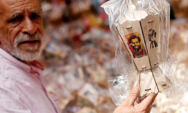 A man buys traditional decorative lanterns known as "Fanous" bearing the image of Liverpool's Egyptian forward soccer player Mohamed Salah at a market, before the beginning of the holy fasting month of Ramadan in Cairo, Egypt May 2, 2018. Arabic words rea