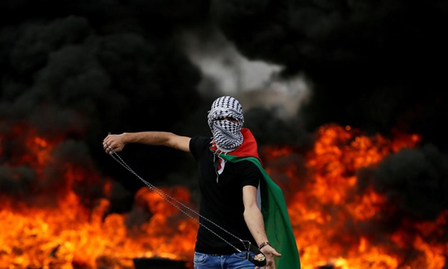 A Palestinian demonstrator holds a sling during a protest marking the 70th anniversary of Nakba, near the Jewish settlement of Beit El, near Ramallah, in the occupied West Bank May 15, 2018. REUTERS/Mohamad Torokman

