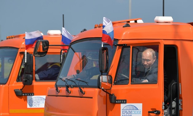 Russian President Vladimir Putin closes the door of a Kamaz truck during a ceremony opening a bridge, which was constructed to connect the Russian mainland with the Crimean Peninsula, near the Taman Peninsula in Krasnodar Region, Russia May 15, 2018. Sput