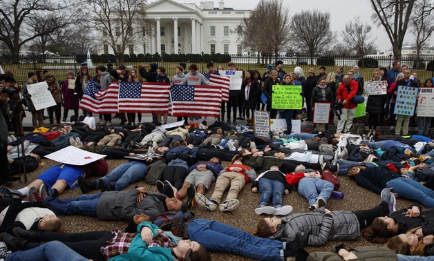 Demonstrators participate in a "lie-in" during a protest in favor of gun control reform in front of the White House. Grassroots groups are planning hundreds more protests in coming weeks. - AFP
