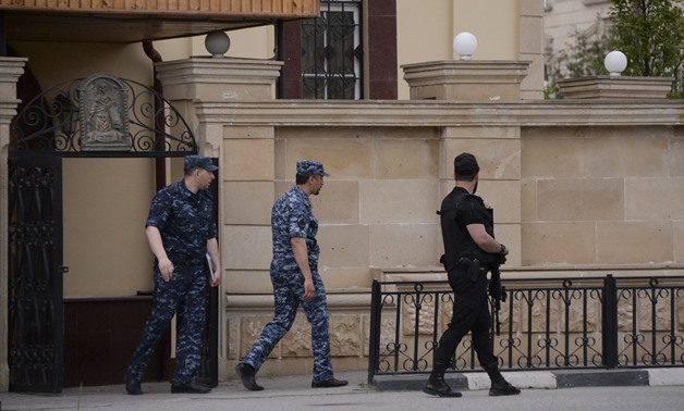 Law enforcement officers walk outside an Orthodox church after the attack of militants in Grozny, Russia May 19, 2018. Picture taken May 19, 2018. REUTERS/Said Tsarnayev