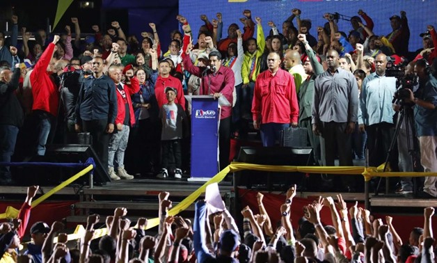 Venezuela's President Nicolas Maduro raises a finger as he is surrounded by supporters while speaking during a gathering after the results of the election were released, outside of the Miraflores Palace in Caracas, Venezuela, May 20, 2018. REUTERS/Carlos 