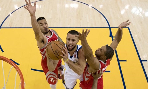 May 20, 2018; Oakland, CA, USA; Golden State Warriors guard Stephen Curry (30) shoots the basketball against Houston Rockets guard Gerald Green (14) and guard Eric Gordon (10) during the first half in game three of the Western conference finals of the 201