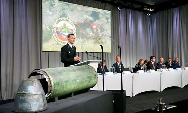 Dutch police officer Wilbert Paulissen, head of the National Crime Squad, is pictured next to a damaged missile as he presents interim results in the ongoing investigation of the 2014 MH17 crash that killed 298 people over eastern Ukraine, during a news c