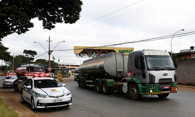 A fuel truck leaves a distrubution plant escorted by police in Brasilia
