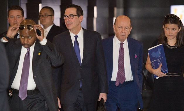 Treasury Secretary Steven Mnuchin (center left) and Commerce Secretary Wilbur Ross (center right) walk through a hotel lobby as they head to a state guest house to meet Chinese officials in Beijing on Friday. The talks included a "thorough exchange of vie