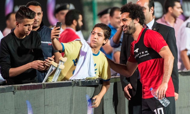 Egypt's national team footballer and Liverpool's forward Mohamed Salah greets fans during the final training session at Cairo international stadium in Cairo on June 9, 2018. -AFP