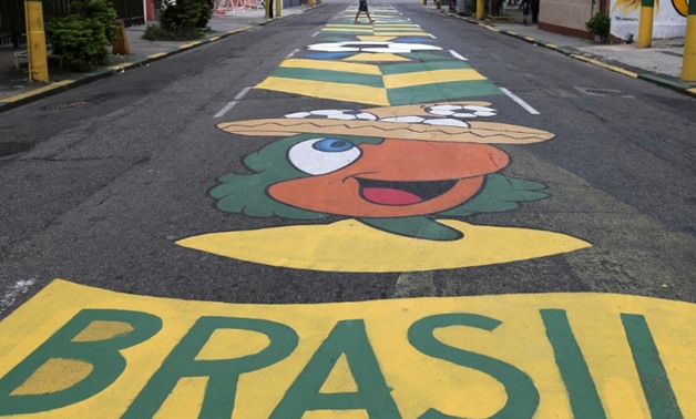 A man walks on a street painted in the colors of the Brazilian flag ahead of the 2018 World Cup, at Vila Isabel neighborhood in Rio de Janeiro, Brazil June 11, 2018. REUTERS/Sergio Moraes