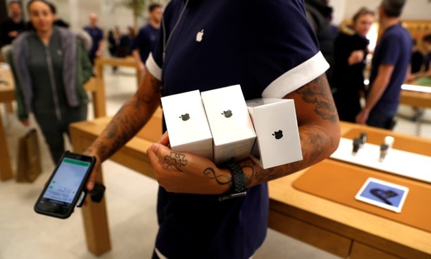 FILE PHOTO: An Apple Store staff shows Apple's new iPhones X - Reuters
