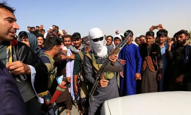 A Taliban (C) stands celebrates ceasefire with people in Rodat district of Nangarhar province
