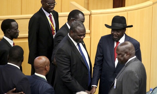 South Sudan's rebel leader Riek Machar (C) shakes hands with South Sudan's President Salva Kiir (black hat) during a peace negotiations attended by leaders from the region in Ethiopia's capital Addis Ababa, August 17 (Reuters)
