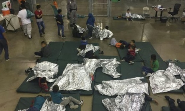 A US Customs and Border Protection photo shows intake of illegal border crossers at a processing center in McAllen, Texas in May - US Customs and Border Protection/AFP/File
