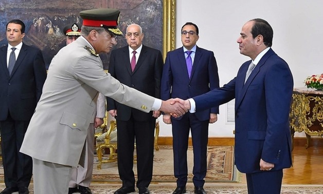 Zaki (L) shakes hands with Sisi after being sworn in as defence minister on 14 June (AFP)