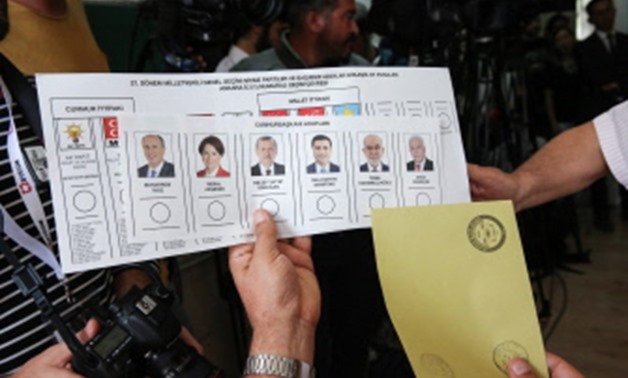 Turkish people hold ballot papers before casting their vote in snap twin Turkish presidential and parliamentary elections in Ankara on June 24, 2018. Turks were voting on June 24, 2018 in dual parliamentary and presidential polls seen as the incumbent Pre