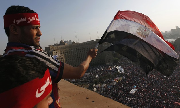 Protesters wave Egyptian flags as demonstrators opposing Egyptian President Mohamed Mursi shout slogans against him and Brotherhood members during a protest at Tahrir Square in Cairo June 30, 2013. Egyptians poured onto the streets on Sunday, swelling cro
