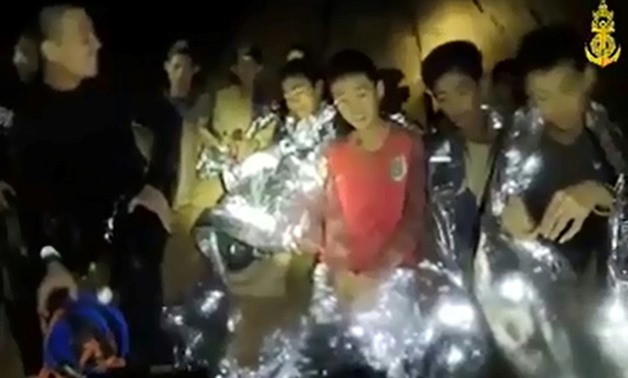 Several of the boys in the frame are wearing protective foil blankets and are accompanied by a smiling diver in a wetsuit, in video clips published on the Thai Navy SEAL Facebook page
