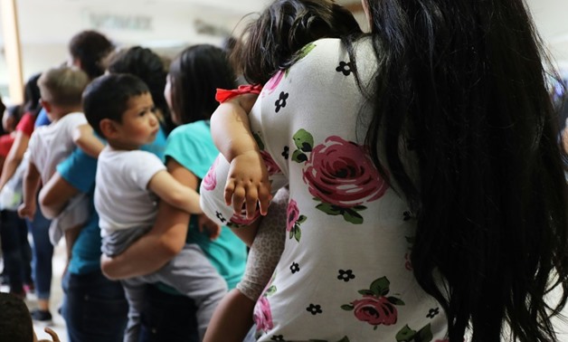 Women and their children, many fleeing poverty and violence in Honduras, Guatamala and El Salvador, arrive at a bus station following release from Customs and Border Protection in McAllen, Texas on June 22, 2018
