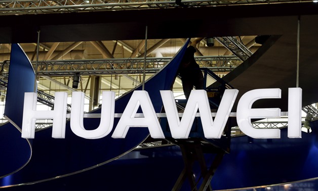 Huawei Phones - Press FILE PHOTO: A worker adjusts the logo at the stand of Huawei at the CeBIT trade fair in Hanover, in this file picture taken March 15, 2015. REUTERS/Morris Mac Matzen