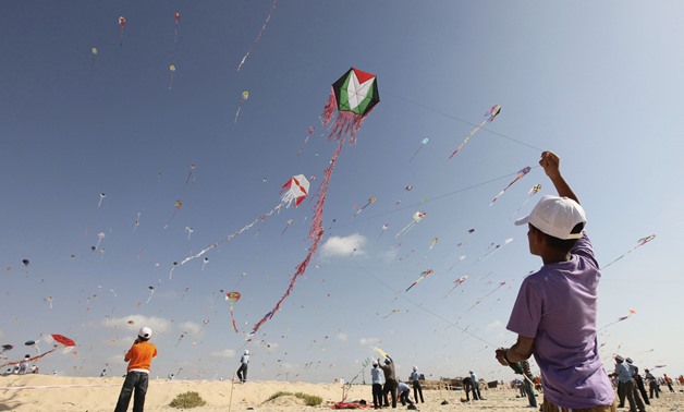 Palestinian children fly kites on the beach of Beit Lahiya in the northern Gaza Strip. Photo by Mohammed Salem/Reuters