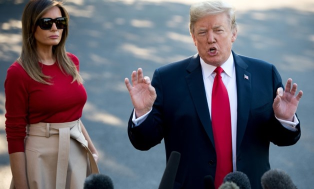 US President Donald Trump speaks alongside First Lady Melania Trump as they walk to Marine One prior to departure for a NATO summit in Brussels

