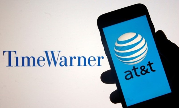 Smartphone with AT&T logo is seen in front of displayed Time Warner logo in this picture - AFP
