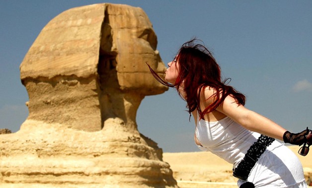 A tourist poses for a picture with the Sphinx at the Pyramids of Giza in Cairo October 19, 2011. REUTERSJamal Saidi
