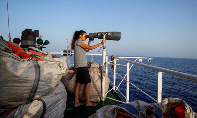 NGO Proactiva Open Arms rescue boat crew member Esther Camps looks through binoculars during a rescue operation in central Mediterranean Sea, July 17, 2018.

