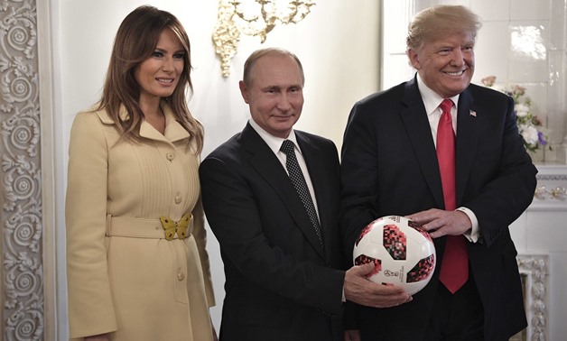 Russia's President Vladimir Putin (C), U.S. President Donald Trump (R) and First lady Melania Trump pose for a picture with a football during a meeting in Helsinki, Finland July 16, 2018. Sputnik/Alexei Nikolsky/Kremlin via REUTERS