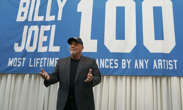 Billy Joel poses under a banner at a press conference to celebrate his achievement of 100 performances at Madison Square Garden in New York-AFP / TIMOTHY A. CLARY
