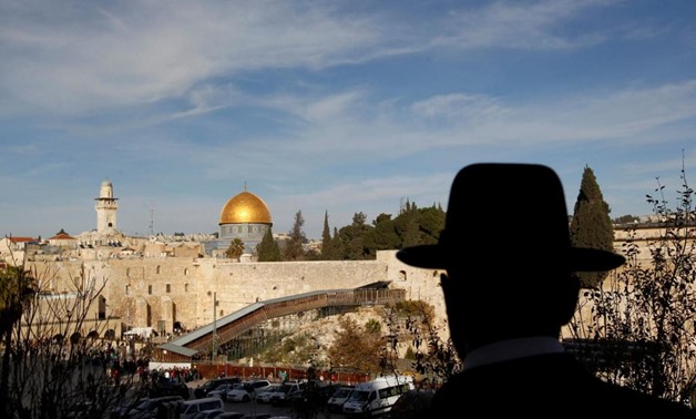 An ultra-Orthodox Jewish man stands at a view-point overlooking a wooden ramp leading up from Western Wall to Noble Sanctuary, where the al-Aqsa mosque and the Dome of the Rock shrine stand, in Jerusalem's Old City December 12, 2011. REUTERS/Ronen Zvulun/