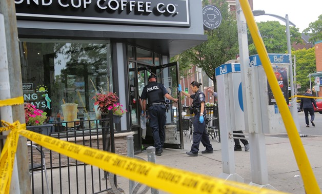 Police officers enter a coffee shop damaged by gunfire while investigating a mass shooting on Danforth Avenue in Toronto, Canada, July 23, 2018. REUTERS/Chris Helgren
